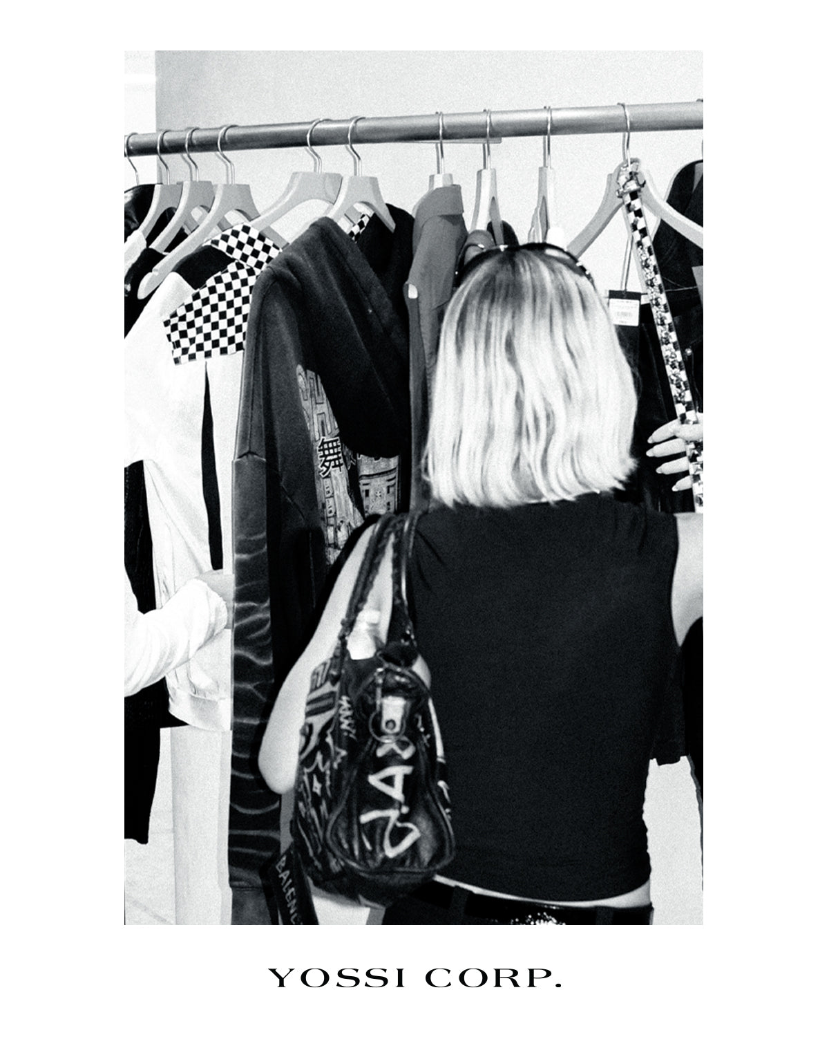 Guest browsing the clothing rail, photographed in black and white