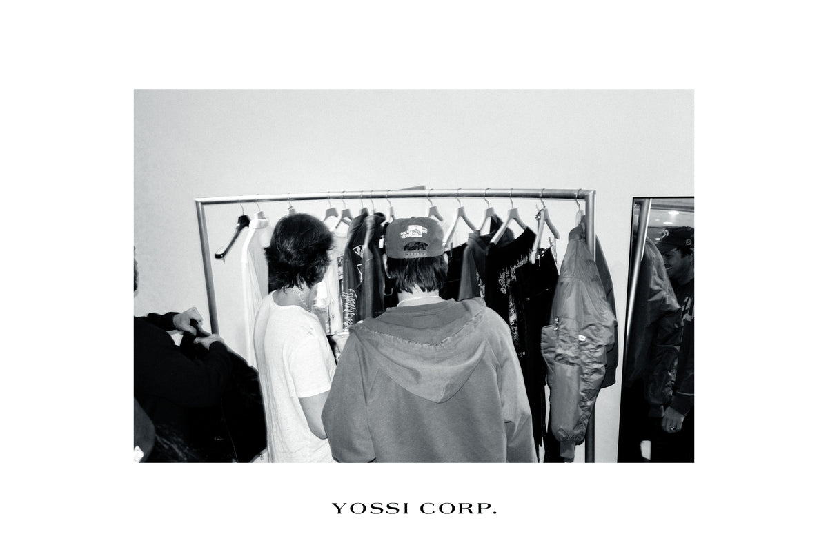 Guests at the clothing rail, photographed in black and white